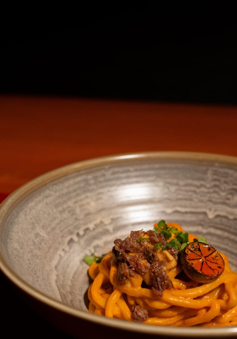 Crab uni and anchovy udon noodles at Goxo plated in artisan bowl